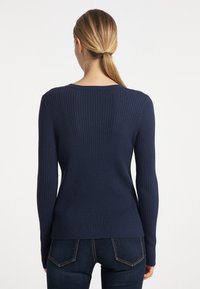 Granatowy sweter prążkowany z długimi rękawami i okragłym dekoltem. Materiał jest teksturowany, dopasowany w talii i ma casualowy fason.