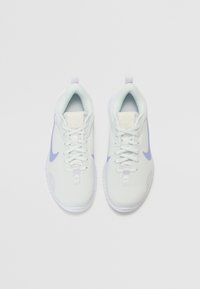 Vaaleansinisiä verkkomateriaalisia lenkkitossuja, joissa on valkoisia yksityiskohtia, litteät nauhat ja teksturoitu pinta. Tossuissa on logo kantapään tarrassa ja kaareva pohja.