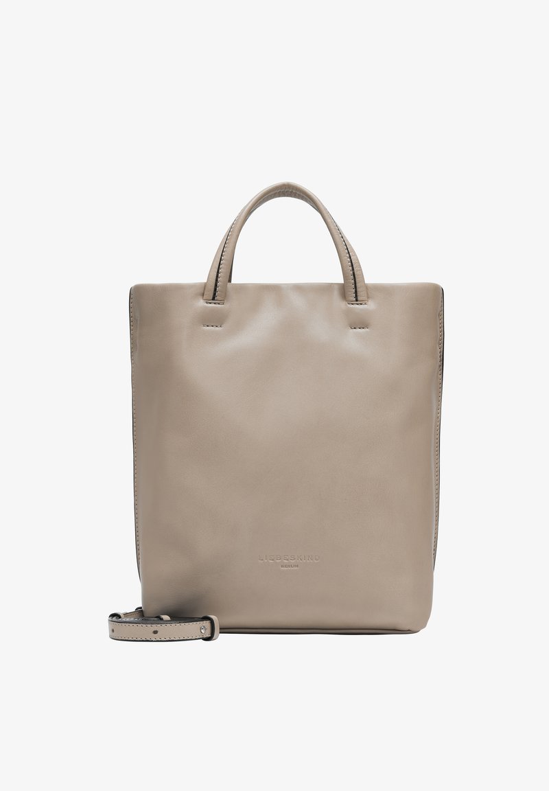 Sac fourre-tout en cuir beige avec deux poignées courtes, une bandoulière amovible, texture lisse et logo en relief à l'avant. Forme carrée.
