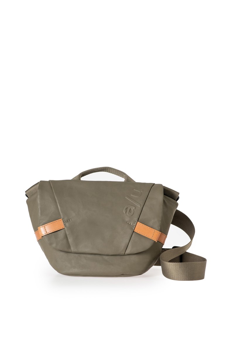 Borsa a tracolla compatta verde oliva con fettucce in pelle marrone chiaro e tracolla regolabile su sfondo bianco.