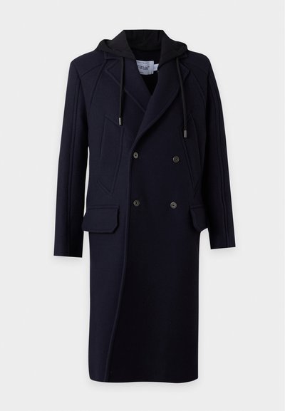 Long manteau noir croisé avec revers, poches avant à rabat et une capuche attachée avec des cordons.