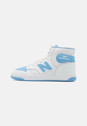 Witte en lichtblauwe New Balance hoge sneaker met blauwe zool, veters en logo op de zijkant en hiel.