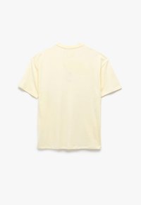Camiseta de manga corta en amarillo pálido, hecha de algodón suave, con un corte relajado, cuello redondo y sin elementos de diseño visibles.