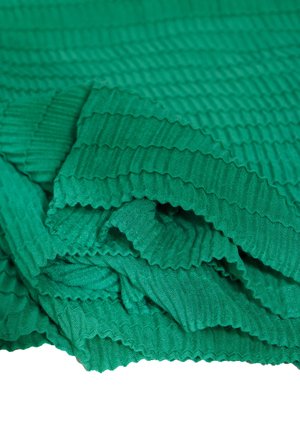 Tissu vert texturé avec un design en relief, présentant des plis doux et une surface lisse. Plusieurs couches créent de la profondeur et de la dimension.