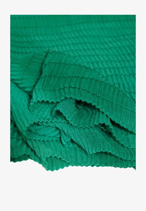 Zielony, teksturowany materiał o żebrowanym wzorze, z delikatnymi fałdami i gładką powierzchnią. Wielowarstwowość tworzy głębię i wymiar.