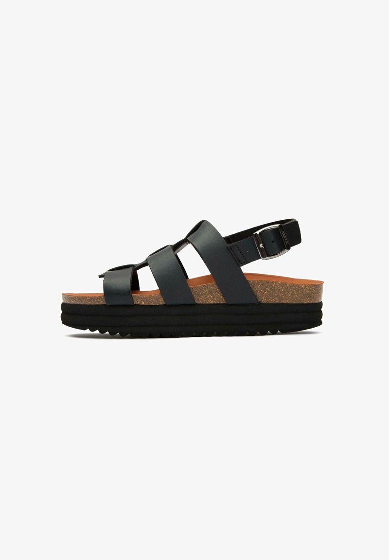 Black leather sandals featuring three wide straps, adjustable ankle buckle, cork midsole, and textured black rubber outsole.