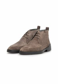Braune Wildleder-Ankle-Boots mit glatter Oberfläche, runder Zehenpartie und kontrastierender dunkler Gummisohle. Verfügt über ein Schnürdesign und eine Zugschlaufe.