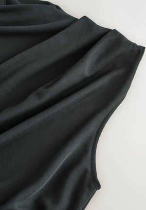 Juodas be rankovių viršus, pagamintas iš lygaus, tampraus audinio, su drapiruotėmis ir apvaliu iškirpimu. Nėra matomų užsegimų.