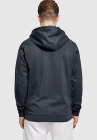 Hoodie gris foncé avec une grande capuche, des poignets côtelés et une texture douce. Le design est simple, sans motifs ni graphiques visibles.