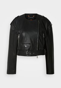 Casaco cropped de pele preta com fecho de correr assimétrico na frente, bolsos com fecho, epaulettes nos ombros e um cinto na cintura com uma fivela metálica.