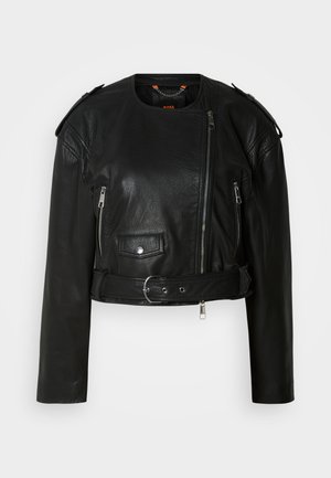 Giacca cropped in pelle nera con zip frontale asimmetrica, tasche con zip, spalline e una cintura in vita con fibbia metallica.