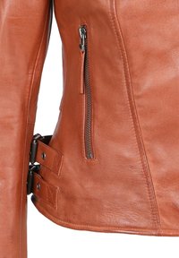 Leren jack in oranje-bruin met een zijrits zak, gespdetails en een gladde textuur. Heeft een getailleerd ontwerp met afgestemde naden.
