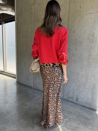 Piros pulóver ballon ujjakbвае és cipzáras részletekkel, hihetetlenül illeszkedő leopárdmintás szoknyával, bézs és fekete színekben, bézs táskával kiegészítve.