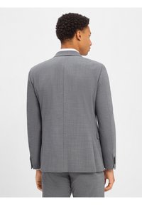 Grijze op maat gemaakte colberts met een gestructureerde stof, notch revers, een enkele split aan de achterkant en knopenmanchetten.