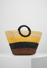 Woven straw tote bag with a round black handle, featuring horizontal stripes in beige, yellow, black, and brown. Textured surface.
