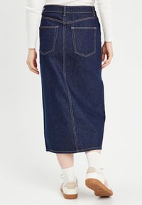 Jupe midi en denim bleu foncé avec une coupe droite, deux poches arrière, des coutures jaunes contrastées et une texture subtile.