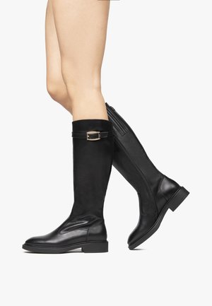 Bottes en cuir noir à hauteur de genoux avec une finition lisse, dotées d'une accent de boucle et d'une fermeture éclair latérale pour un enfilage facile. Bout carré et talon bas.