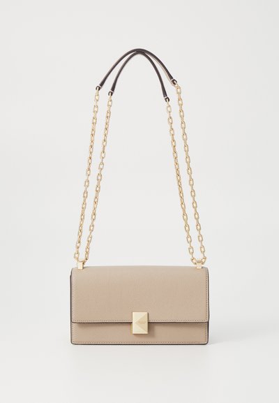 Beige leather handbag with gold chain straps, rectangular shape, textured surface, and a prominent square clasp detail on the front.