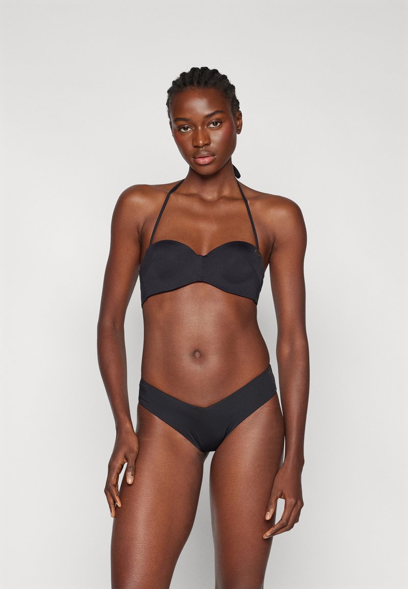 Ensemble de bikini noir comprenant un top bandeau au design lisse et sans coutures avec des bretelles réglables, associé à un bas de bikini taille basse en forme de V.