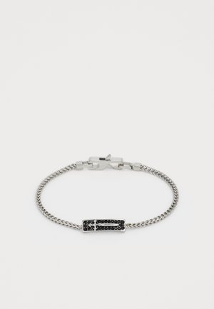 Bracelet en chaîne argentée avec incrustation de pierre noire rectangulaire, présentant un design de épée en argent et une fermeture à clasp de homard.