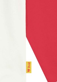 Half-white, half-red cotton t-shirt with short sleeves. Features a yellow label with a bear logo near the hem. Smooth texture, casual design.