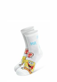 Calze di cotone bianche con un grafico colorato di SpongeBob SquarePants e la scritta blu "HA HA HA" vicino alla cima. Lunghezza a metà polpaccio.