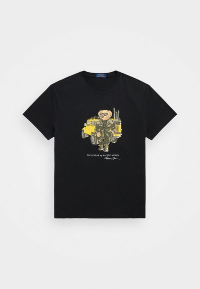 Tricou negru din bumbac, cu un grafic al unui urs îmbrăcat în haine verzi lângă un vehicul galben, având textul "POLO BEAR by RALPH LAUREN" dedesubt.