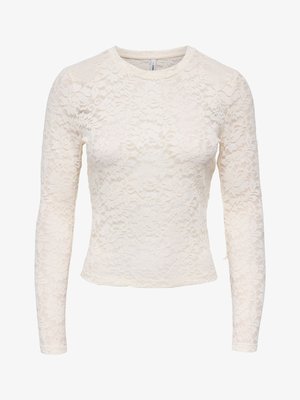 Biała bluzka z długim rękawem z koronki w kwiatowy wzór, z okrągłym dekoltem, dopasowanym krojem i lekko skróconą długością.