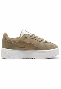 Sneaker in suede beige con suola piatta bianca e testurizzata, caratterizzati da un collo imbottito, logo dorato sulla linguetta e chiusura con lacci classica.