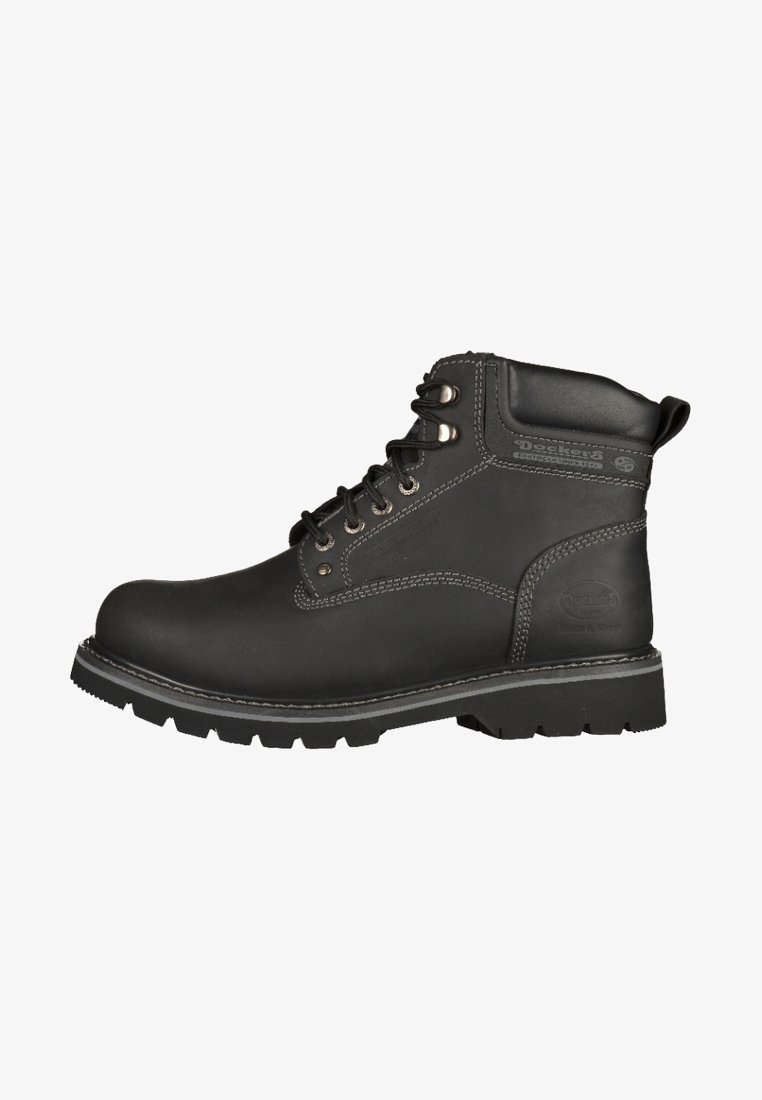 Botte de travail en cuir noir au design robuste, avec un embout renforcé, des œillets en métal et une semelle épaisse et robuste. Détails de surpiqûres contrastés.