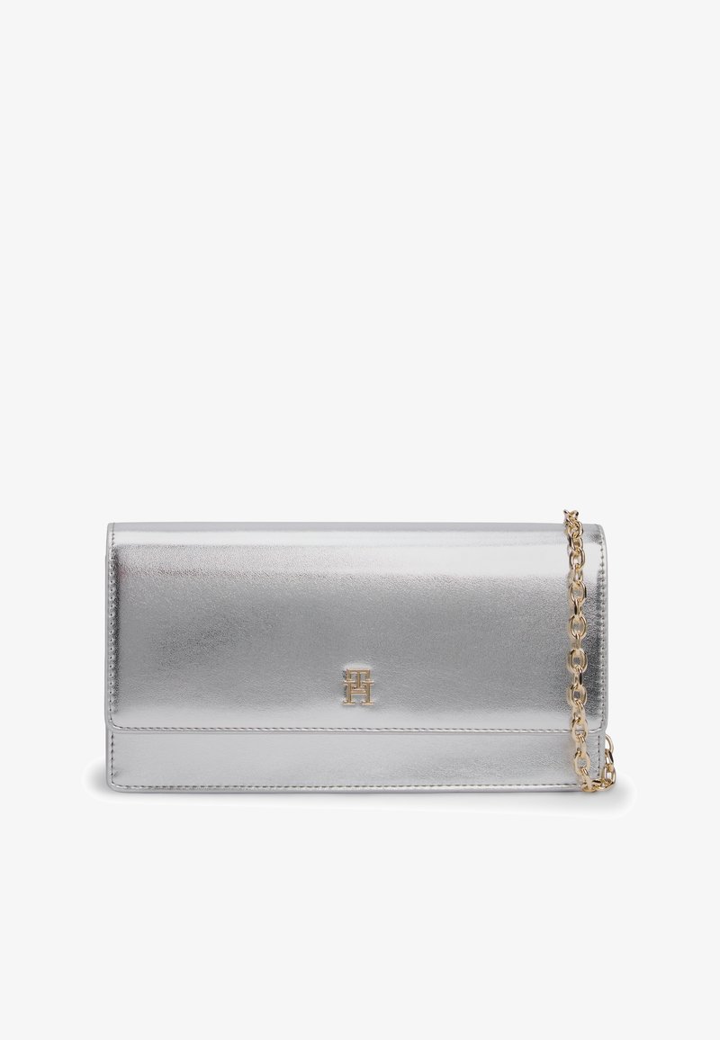 Ασημένια ορθογώνια τσάντα clutch με χρυσή αλυσίδα ιμάντα και ένα μικρό χρυσό λογότυπο τοποθετημένο στο κέντρο της εμπρόσθιας πτυχής.