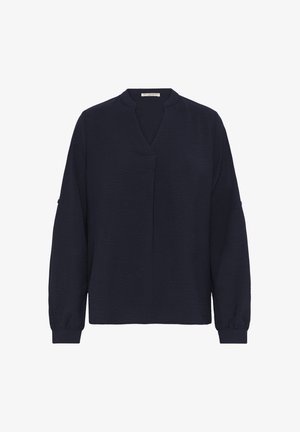 Blusa de manga larga azul marino con escote en V y corte holgado. Tejido texturizado, puños elásticos y un sutil detalle de costura central.