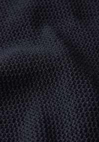 Marinblått tyg med en texturerad, vävd modell, som har en andningsbar meshstruktur. Mjuk, matt yta och djupblå färg.