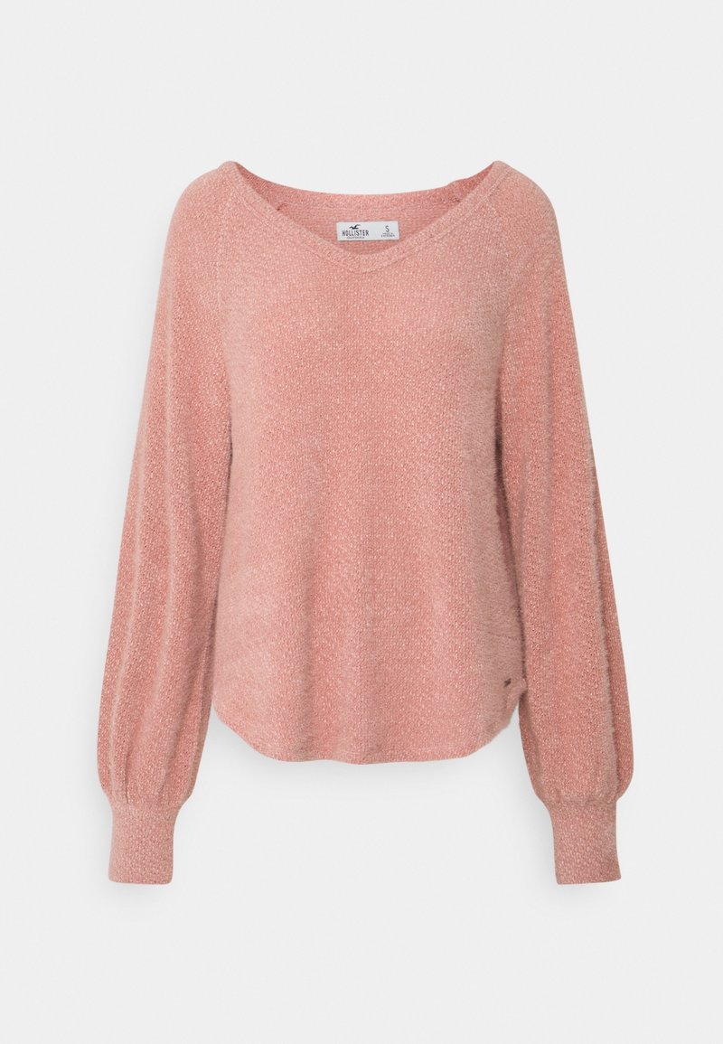 Maglione rosa, dalla trama elaborata, con scollo a V, maniche lunghe a palloncino e un orlo leggermente curvo. Realizzato in un materiale morbido e leggero.