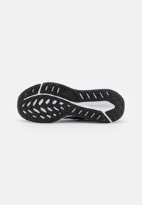 Suela de zapato de goma negra con patrón texturizado, que incluye surcos y crestas para tracción. Acento blanco incrustado a lo largo del centro.