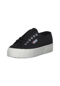 Black canvas sneaker with a rounded toe, white rubber sole, silver eyelets, and laces. Features a logo patch on the side.