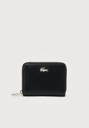 Portafoglio compatto in pelle nera testurizzata con logo coccodrillo argentato e chiusura con cerniera a tutto giro su sfondo neutro.