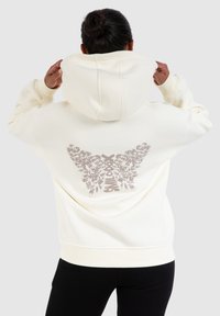Crèmefarbener Kapuzenpullover mit einem floralem Flügeldesign in sanftem Rosa auf dem Rücken, mit gerippten Bündchen und Saum.