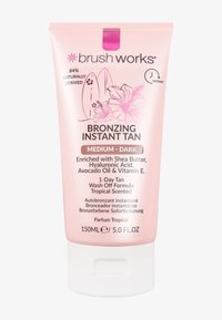 Crème bronzante instantanée Brush Works, teinte moyen-foncé, tube de 150 ml avec des graphiques de planches de surf et de fleur d'hibiscus. Enrichie en ingrédients naturels.