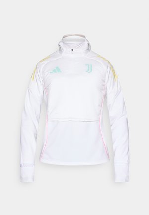 Witte trainingsjack met lange mouwen en een halve ritssluiting bij de kraag. Voorzien van lichtblauwe en gele accenten, plus roze bies langs de taille.