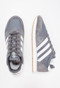 Gray and white Adidas sneakers with suede and mesh details, white stripes, lace-up front, and rubber soles shown from top and side views.