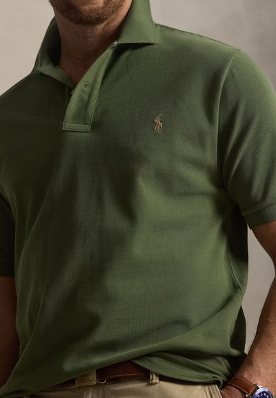 Πράσινο πόλο με κοντά μανίκια, υφασμάτινη υφή, τριάκτινο πατιλέτο και μικρό κεντημένο λογότυπο στο αριστερό στήθος.