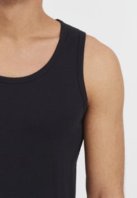 Zwarte katoenen tanktop met een ronde halslijn en brede schouderbanden, met een zachte textuur en een aansluitend ontwerp.