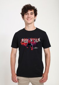  camiseta negra de algodón con un gráfico colorido del personaje "Red Hulk" con acentos en rojo y azul intensos y texto estilizado.