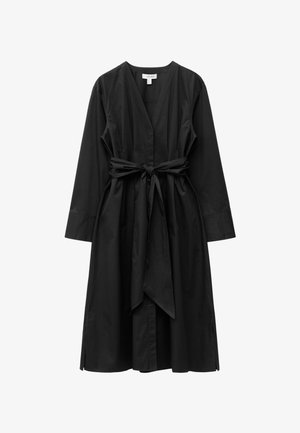 Schwarzes Wickelkleid aus leichtem Stoff, mit tiefem V-Ausschnitt, langen Ärmeln und einem abnehmbaren Bindegürtel in der Taille.