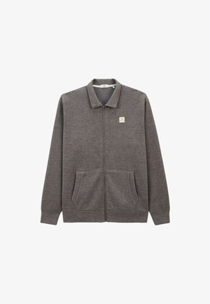 Veste zippée en polaire grise avec un col, deux poches avant et un petit logo brodé sur le côté supérieur gauche. Texture douce et design décontracté.