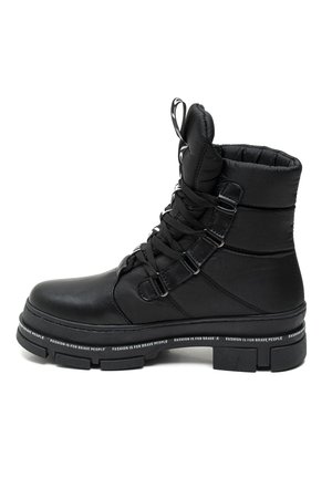 Schwarze Knöchelstiefel mit gepolstertem Schaft, Schnürverschluss und dicker Gummisohle. Verfügt über ein Logoband an der Sohle und eine Zuglasche am Hinterteil.
