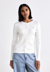 Witte gebreide cardigan met een kabelpatroon, ronde halslijn en knopen aan de voorkant. Casual pasvorm met ribgebreide boorden en zoom.