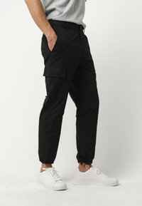 MELA RAJESH - Cargobroek - schwarz