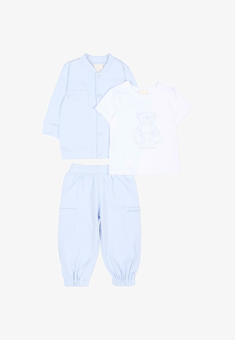 Blouson bébé bleu clair avec poches avant et boutons-pression, pantalon assorti avec poignets élastiqués, et t-shirt blanc avec imprimé ours en peluche.